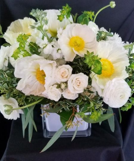 A cream and white assortment of some of the seasons finest flowers including Poppies and Ranunculus.
